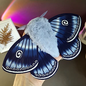 Blue moth plush doll on a hand