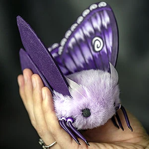 A realistic insect figurine, a purple moth plush doll, crafted with meticulous attention to detail and featuring soft faux fur