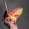 Rosy Maple Moth plush doll handmade art toy with pink and yellow wings held in hand