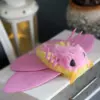 Rosy Maple Moth plush doll viewed from below showing pink legs and soft yellow belly – handmade collectible art toy with detailed underbody