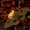 Yellow Io Moth art doll with golden wings on an old brick wall in warm evening light